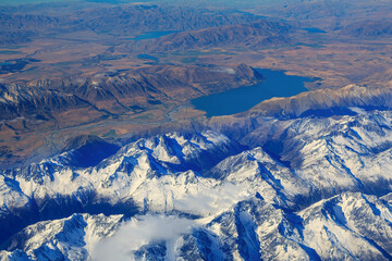 Naklejka premium Aerial view of the snowy mountains of the Southern Alps in the South Island of New Zealand. Behind them are Lake Ohau and the Hopkins River