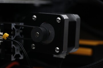 Fototapeta na wymiar Side view of stepper motor driven heating or printing bed of three dimensional printer in short 3D Printer
