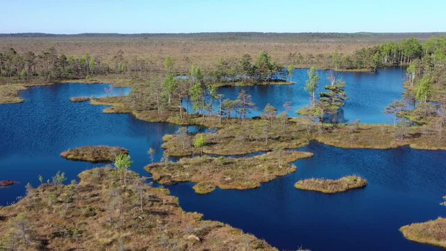 Aerial orbiting shot around small lakes in peat bog