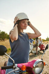 Smiling young caucasian girl putting on safety helmet