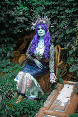 fabulous dark mermaid with blue skin in the forest close up