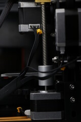 Wires connect to stepper motors of 3d printer with threaded rod visible that contributes to 3D printing process