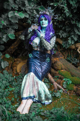 Obraz premium fabulous dark mermaid with blue skin in the forest close up