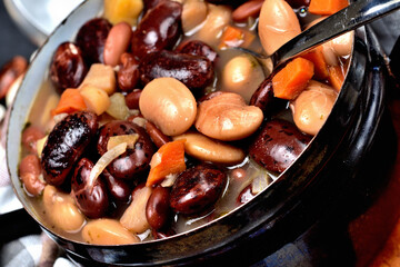 Detail of bean soup with large beans in an old enamel pot.