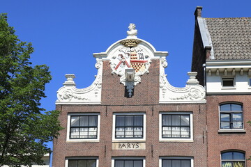 Fototapeta na wymiar Amsterdam Historic Oudezijds Voorburgwal Canal House with Decorated Neck Gable, Gable Stone and Sculpture