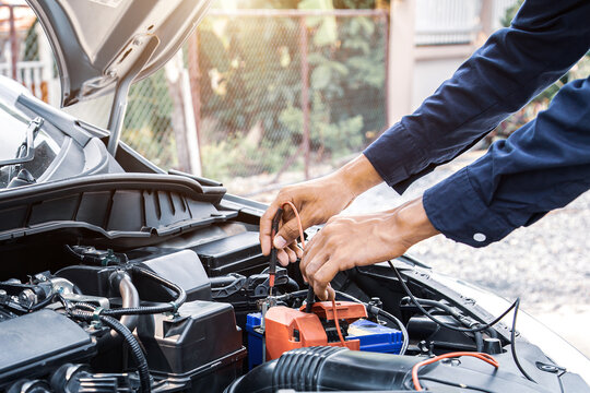 Technician Auto Mechanic Using A Power Meter To Check The Car Batter Electric Or Electrical And Engine System For Service Repairing Maintenance And During The Old Car Is Periodic Inspection.