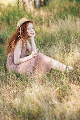 Fototapeta na wymiar Red hair young girl in the field of summer