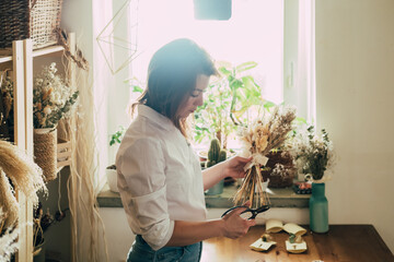 Beautiful Florist Arranging Bouquet of a Dry Flowers at her Workshop
Young talented woman cutting with scissors dried plants and flowers arrangement in her flower shop, sustainable lifestyle concept. - Powered by Adobe