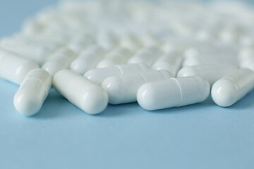 White medical pills isolated on blue background