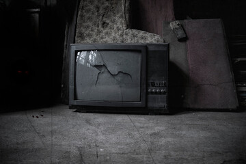 Old TV in the room of an abandoned house. Shabby walls and floor. The dark atmosphere of an...