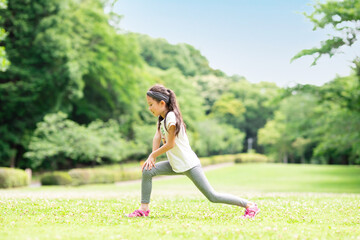 芝生でストレッチをする少女