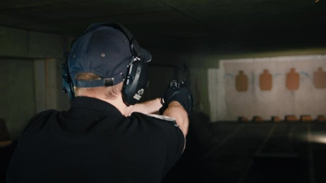 Krivoy Rog, Ukraine - 06.11.2021: police shooter trains to shoot against the clock with an instructor from a pistol, in a special shooting range. Prores422