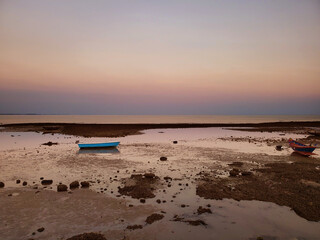 Fall of sea levels at sunset with fish boats tides