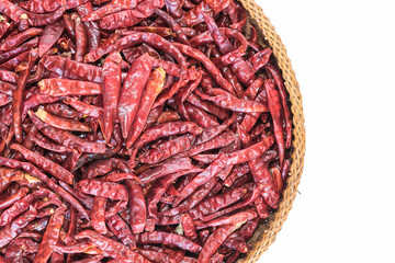 Many sun dried red hot chili pepper arranged on a wooden basket