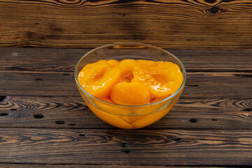Canned peaches in a glass bowl on the table.