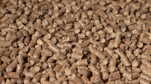 Close-up view 4k stock video footage of brown organic wooden granules (pellets) isolated
