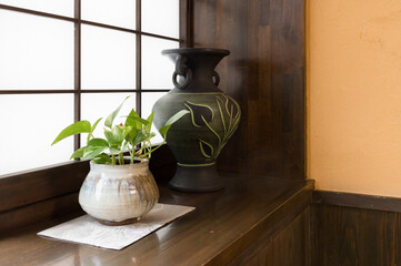 和室の窓際に飾られた花瓶と観葉植物
