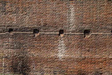 An old red brick wall with traces of soot.
