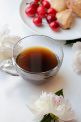coffee, homemade cookies and cherry with peony flowers