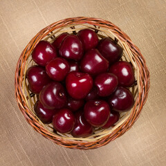 Cherry in a wicker basket on linen