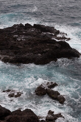 mar con rocas dentro del mar color azul, olas