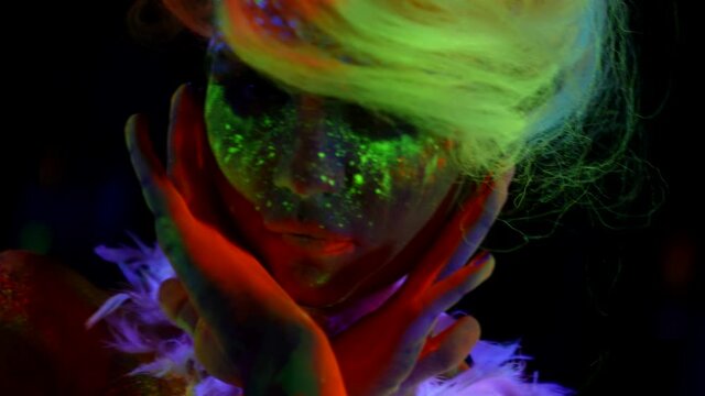 extravagant mysterious image with using fluorescent paints, woman is covered by glowing patterns