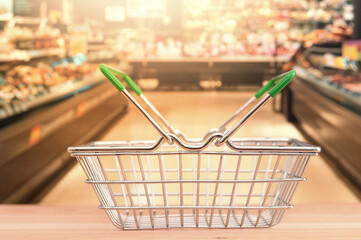 Empty shop basket on blurring supermarket aisle background