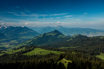Fototapeta premium Panoramic landscape view of the Swiss Alpes,with blue sky in the background, shot in La Berra, Gruyère, Switzerland