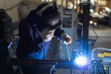 Skillful welders weld steel in the factory. Construction site metal welder.