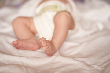 Baby legs on white sheet, newborn baby 1 month, care and love with copy space. High quality photo