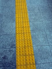 The yellow pavement has a textured surface to serve as a walking guide for the visually impaired