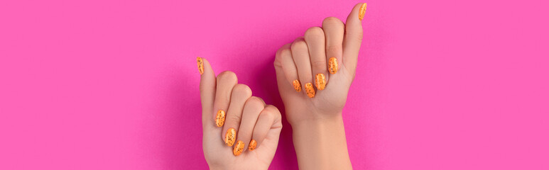 Manicured womans hands with trendy nail design on pink background