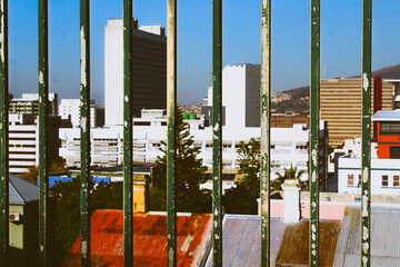 Buildings are seen through rusted bars in cape town 