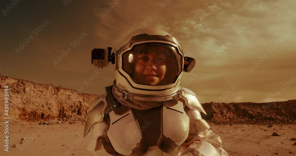 Wall mural female astronaut looking at camera on mars