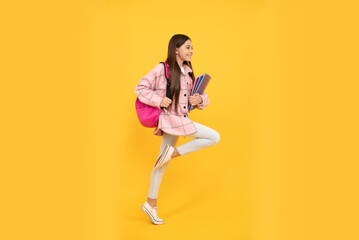 Fototapeta na wymiar happy kid girl wear pink checkered shirt running with school bag and notebooks, hurry up