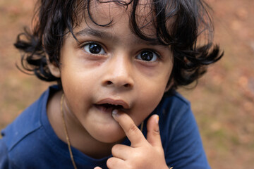 Close-up face of a cute little girl  staring at camera with curiosity