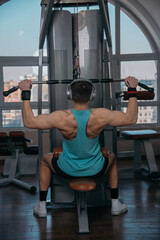 Handsome athlete working out at gym. Pull ups, exercising back. Fitness people.