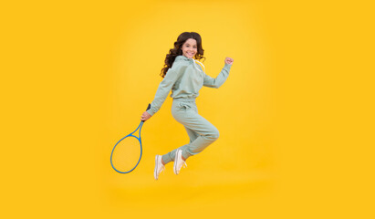 Fototapeta na wymiar happy energetic child jump in sportswear with squash racquet on yellow background, sport success