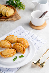 curry puff or kari pap is a snack of Maritime Southeast Asian origin.  It is a small pie consisting of curry with chicken and potatoes in a deep-fried or baked pastry shell. 