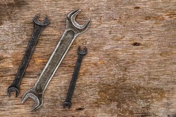 A lot of old wrenches. The working set of wrenches on cracked plywood background.