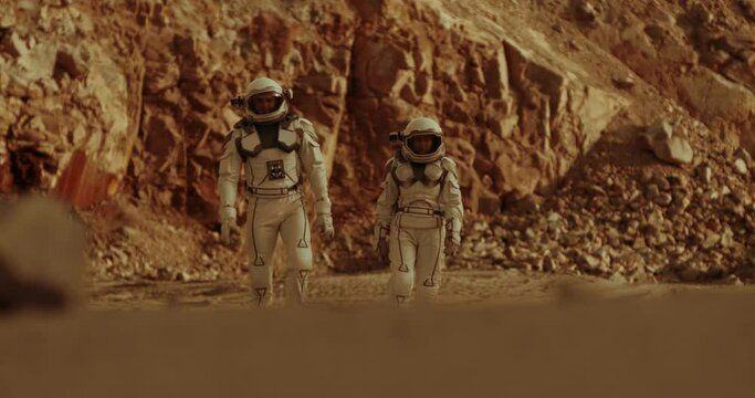 Male and female cosmonauts walking on Mars