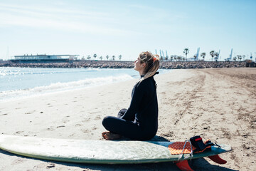 woman sitting on the beach with surfboard.Summer concept.