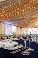 Champagne glasses. Candles and flowers. Banquet table decoration.