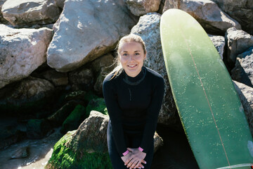 Portrait of a caucasian girl on the beach with a surfboard