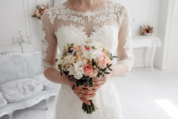 The bride holds a bouquet of roses. Beautiful wedding bouquet. The morning of the bride.