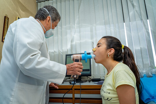 Hispanic young woman performing pulmonary function test and spirometry in doctor office