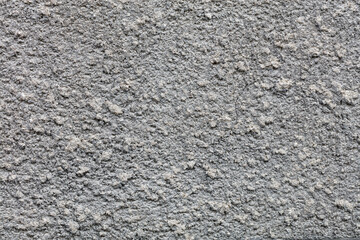 Texture and background of a gray textured wall covered with a cement coat.