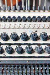 Fragment of the thread tension control unit on an industrial embroidery machine, close-up.