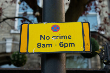 A sign ironically declares "No crime 8am - 6pm".