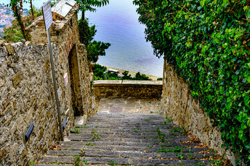 Castellabate, Salerno, Italy. Country lane with stairs and green plant and sea